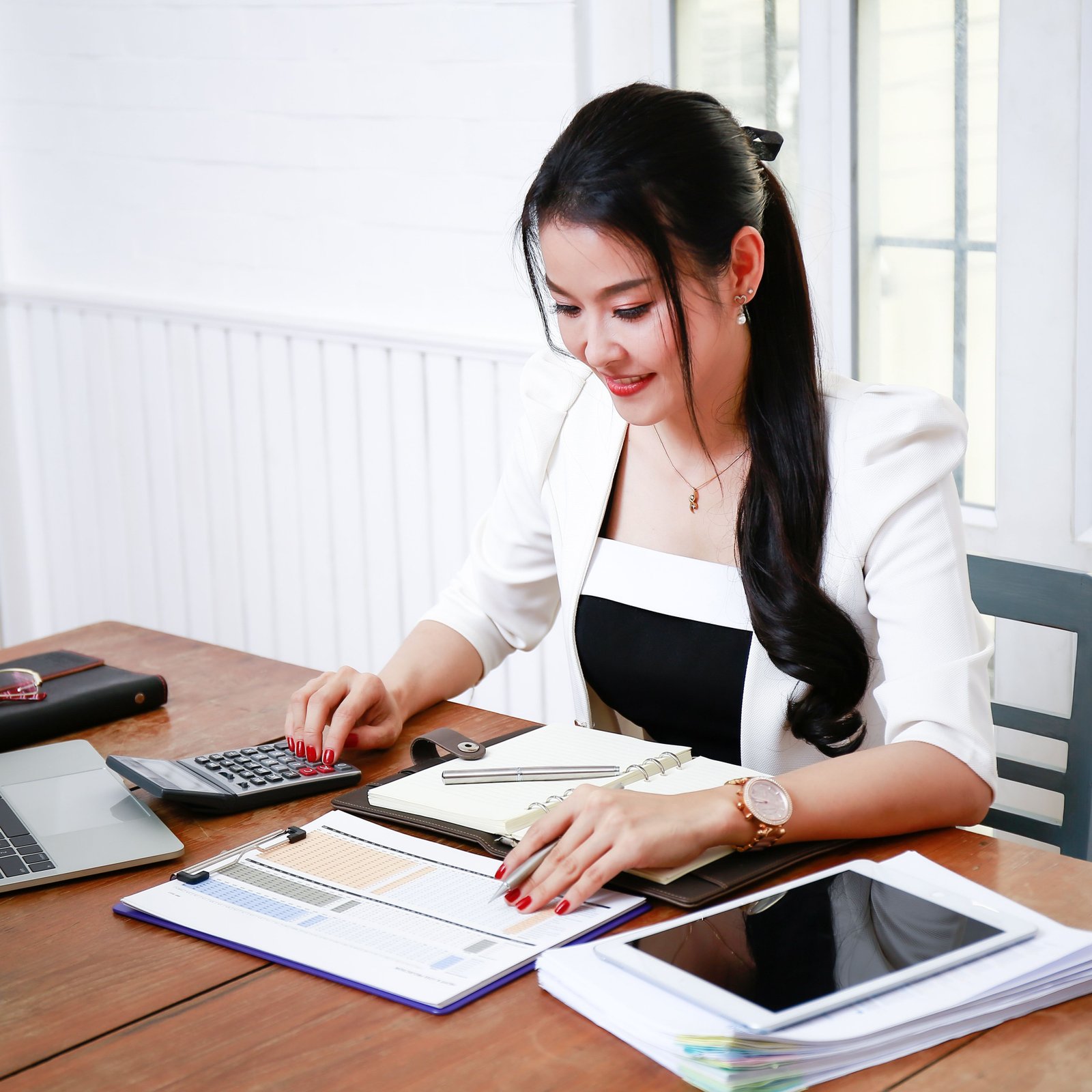 A desk with tax forms, a passport, and a calculator arranged neatly